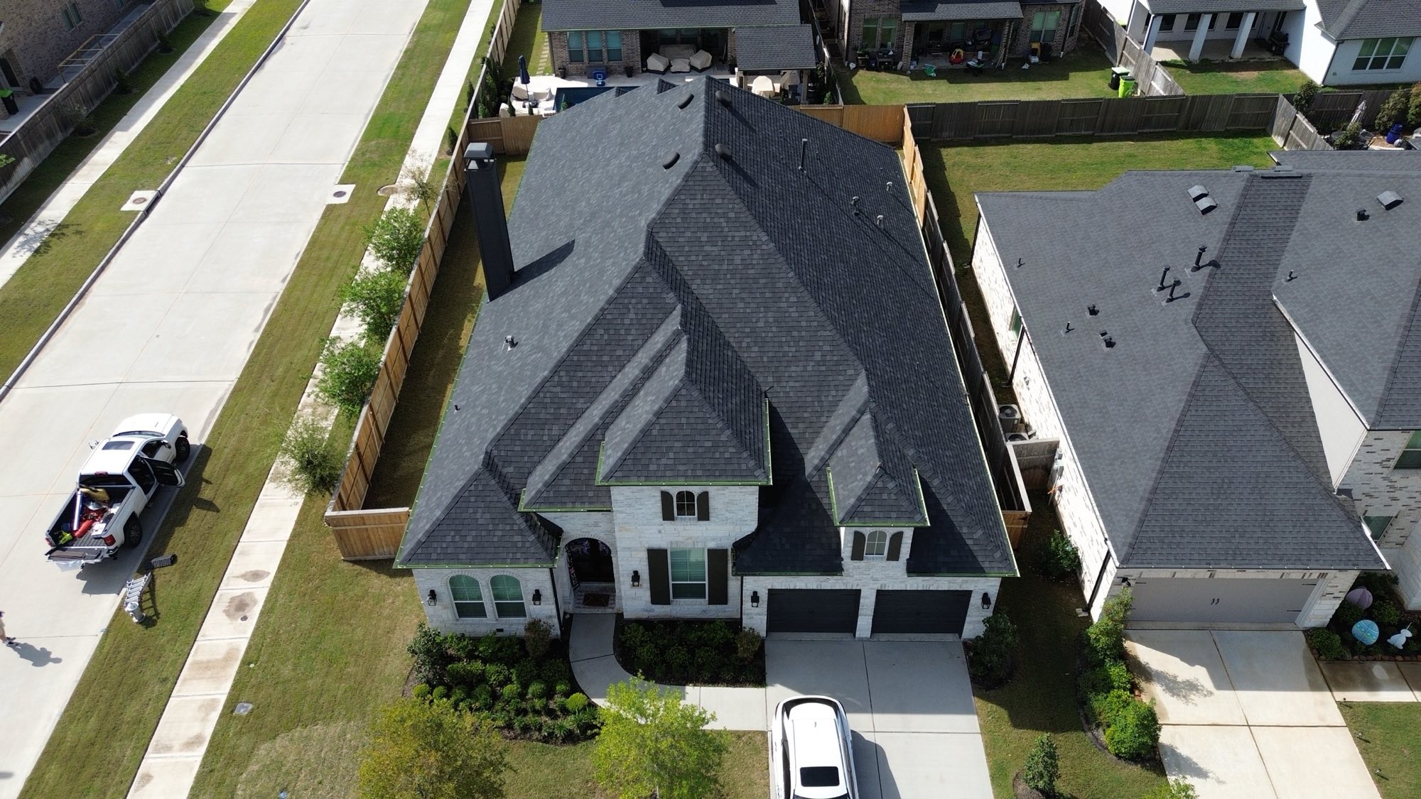 Aerial view of completed residential roof replacements in a West Houston neighborhood