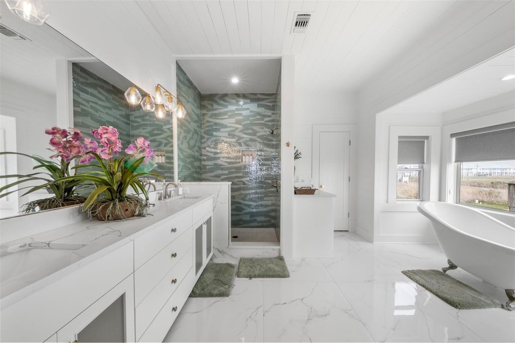 Primary bathroom with freestanding soaking tub and glass tile shower